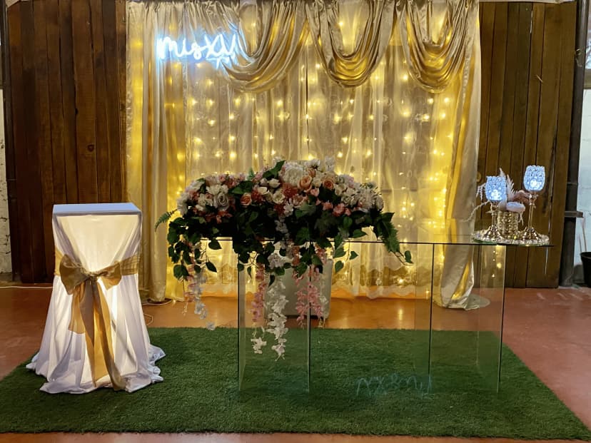 Mesa de honor número 1 decorada con detalles dorados y flores, en un ambiente elegante con iluminación cálida.