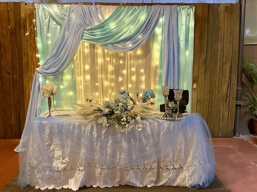 Mesa de honor número 17 decorada en tonos azul y amarillo con luces y un elegante arreglo floral que resalta el ambiente.