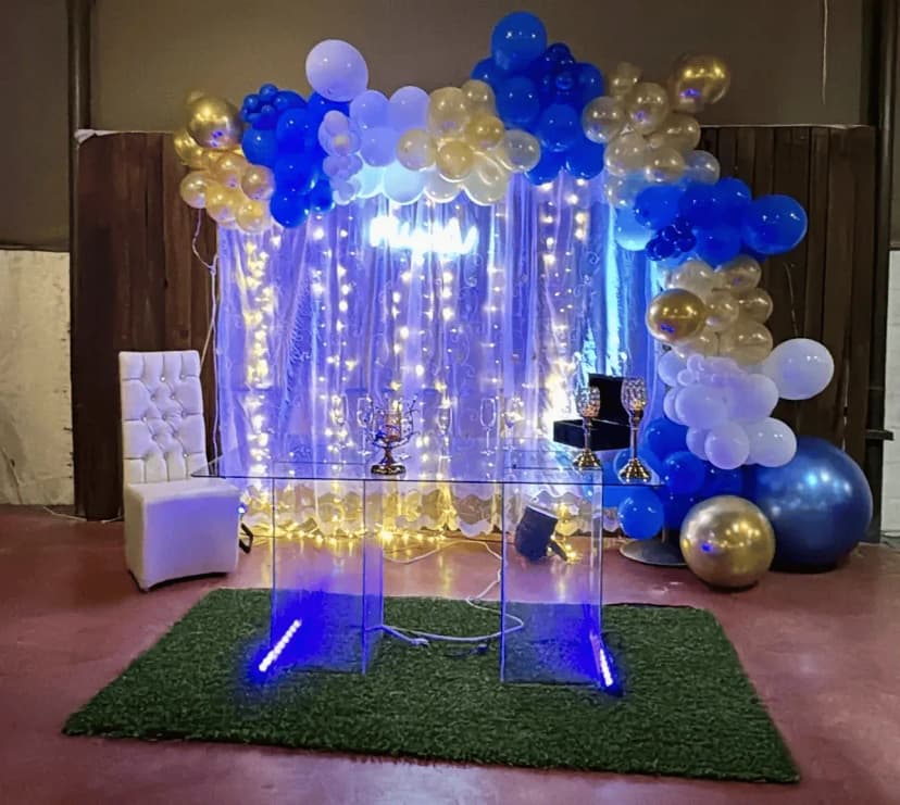 Mesa de honor número 3 con globos azules, dorados y blancos, además de iluminación neón que resalta un estilo moderno.